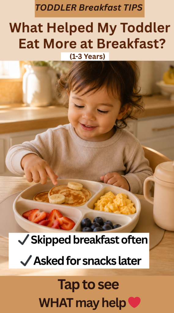 Toddler sitting at breakfast table with pancakes, fruit, and eggs on a divided plate in warm morning kitchen lighting with text overlay “What Helped My Toddler Eat More at Breakfast?”